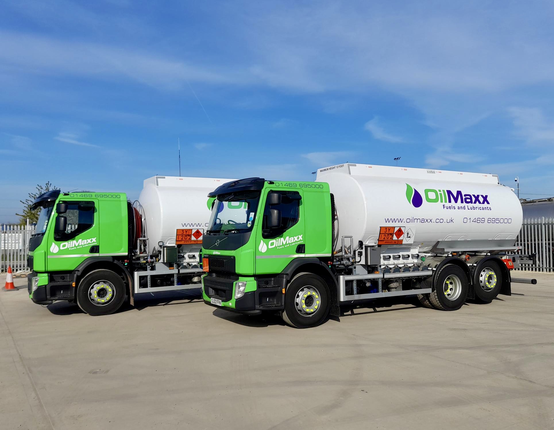 two oilmaxx oil tankers with the logo on the side of the tanker in a yard