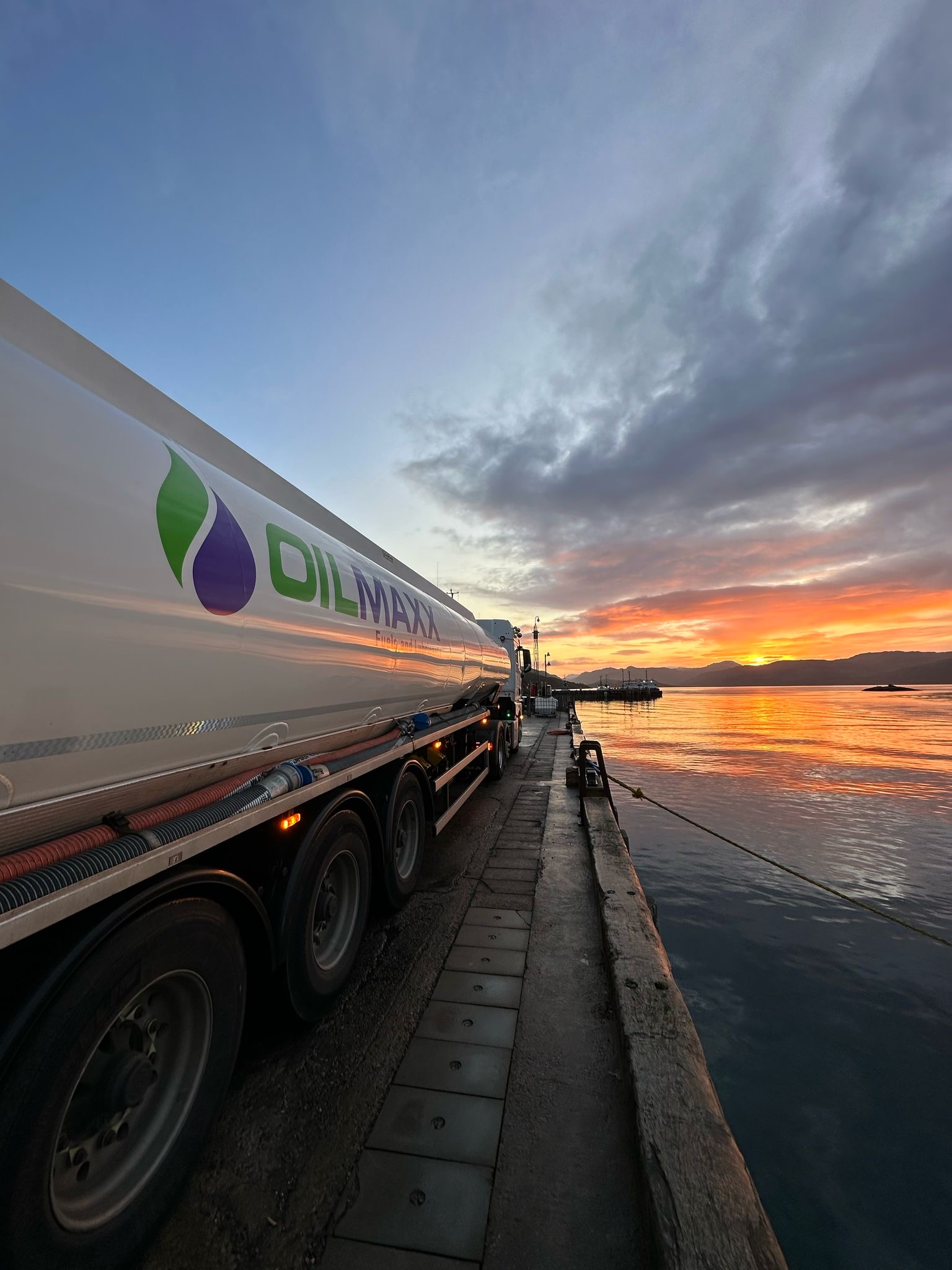 two oilmaxx oil tankers with the logo on the side of the tanker in a yard